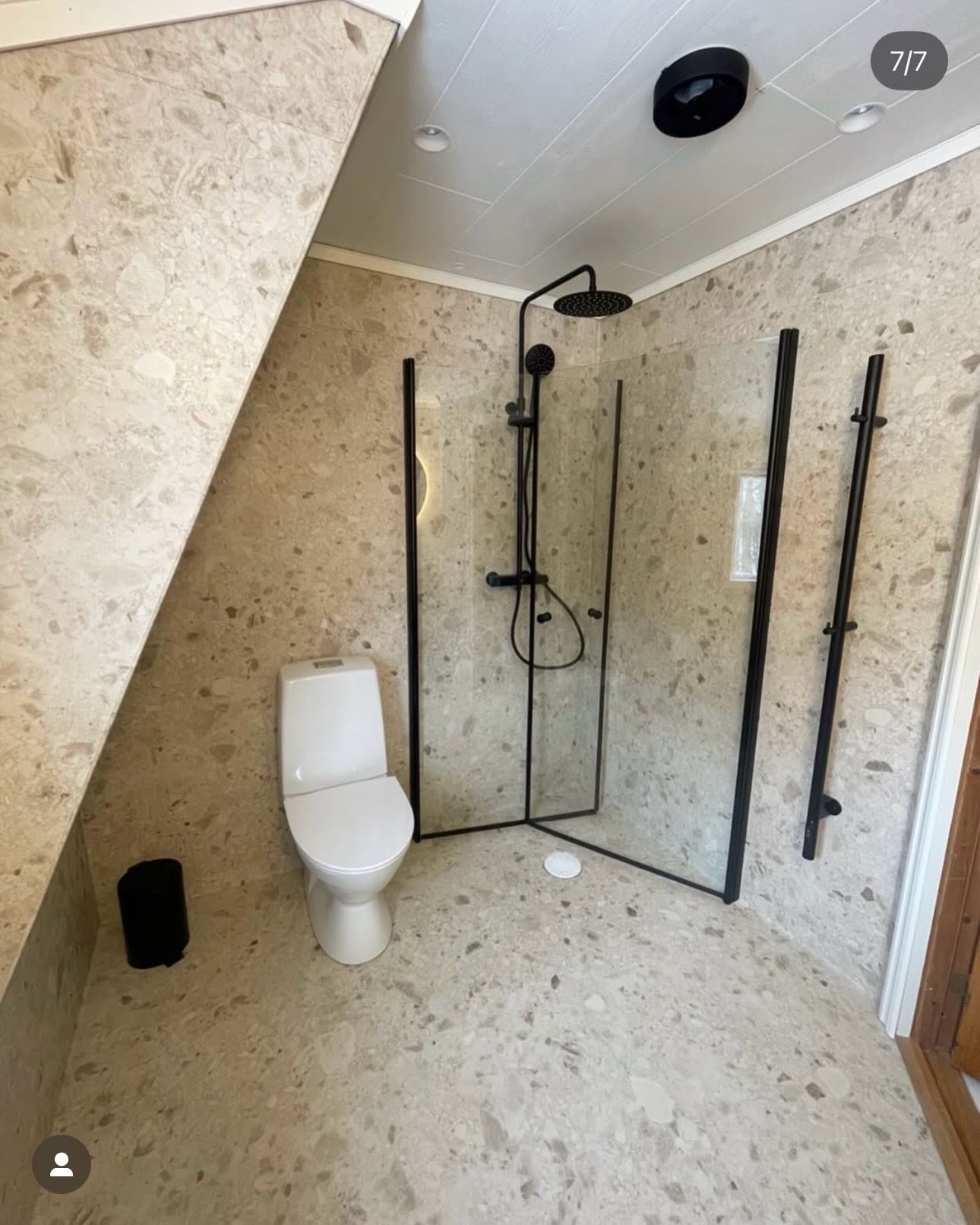 Hörndusch med terrazzoplattor och mattsvarta duscharmaturer