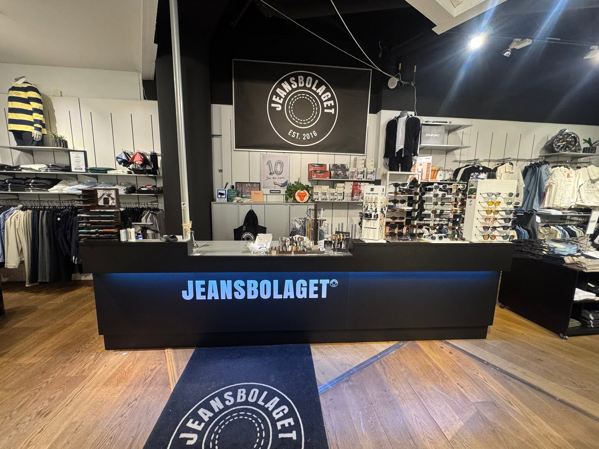 Överblick av Jeansbolagets butik med kassa, klädställ och skyltning