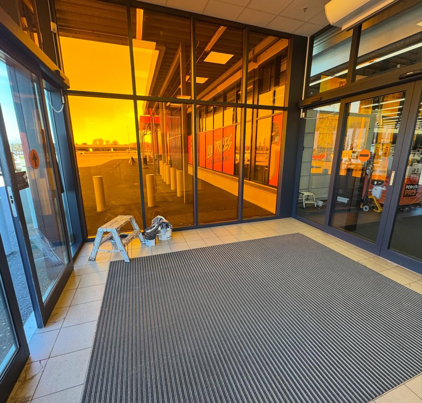 Glasentré till Power-butik med svarta karmar och entrématta