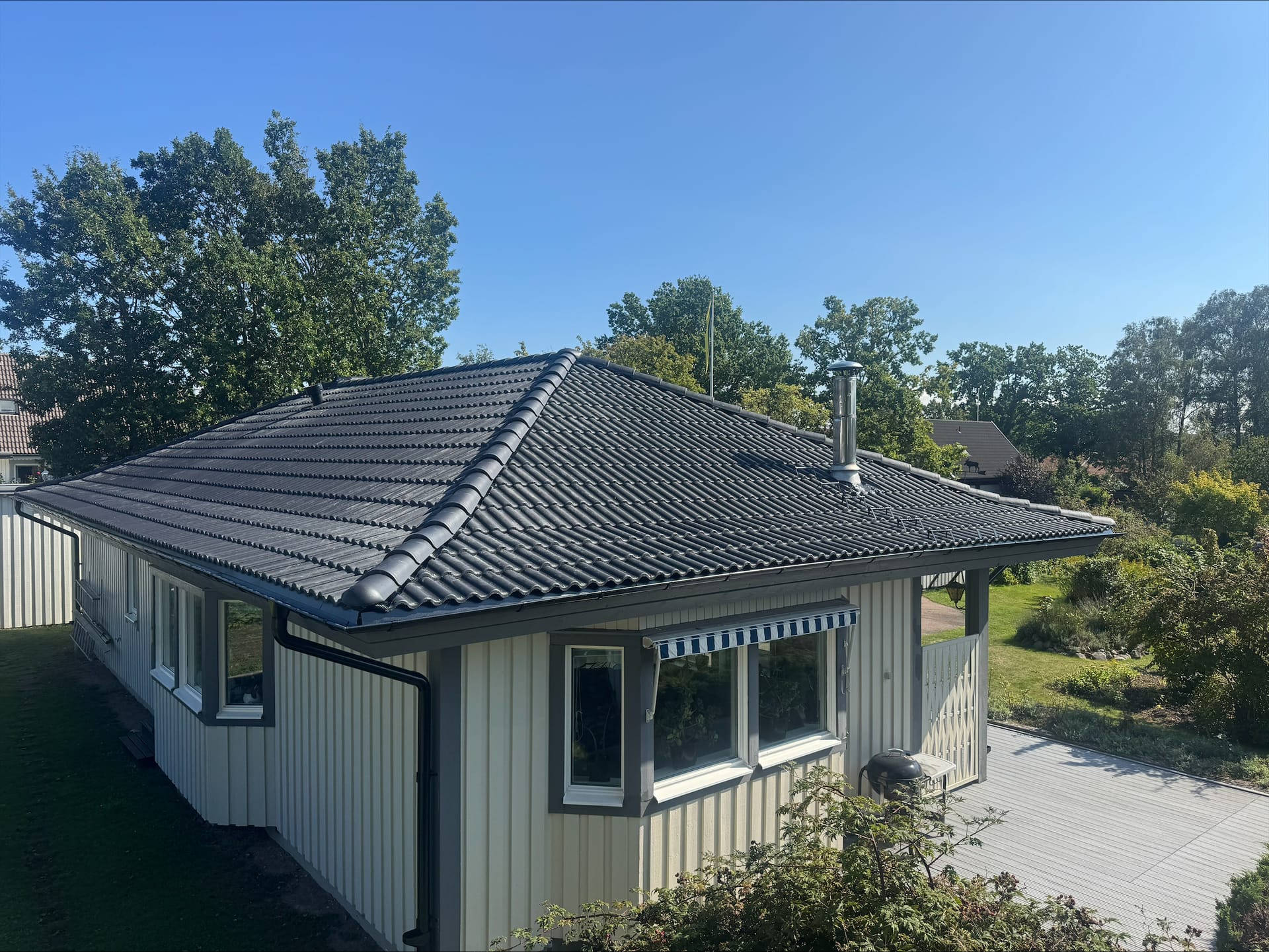 Villa med grått tak och uteplats